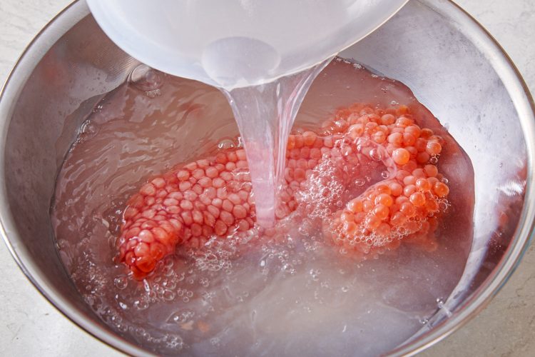 筋子を塩を加えた70℃の湯に漬ける