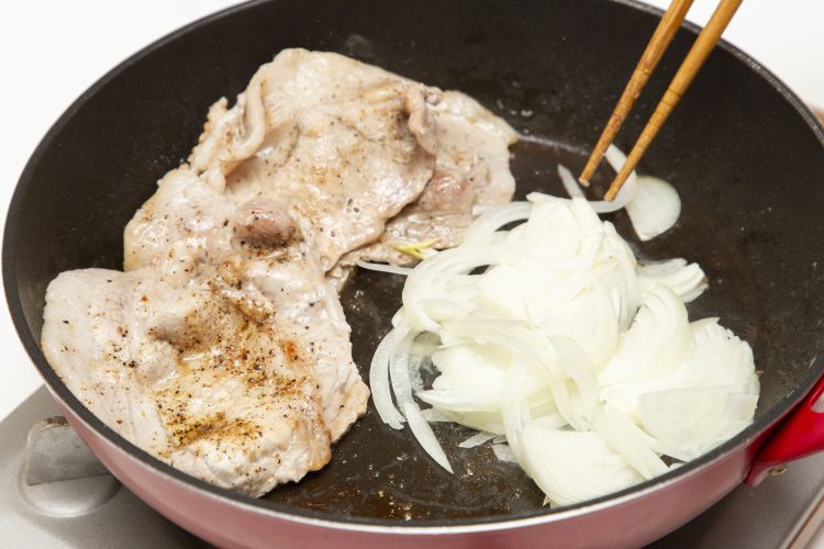 豚肉の表面が焼けたらフライパンの端に寄せて玉ねぎを炒める
