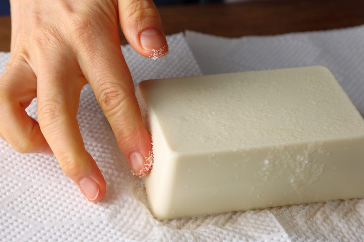 豆腐に塩をつけている様子