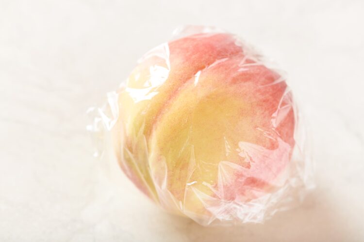 洗った桃をラップに包む