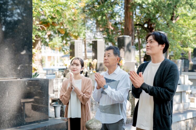 家族でお墓参りをしているイメージ