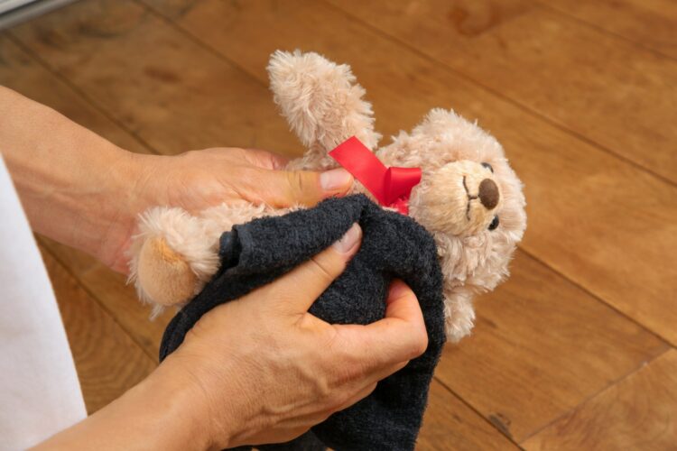 ぬいぐるみをタオルで拭く