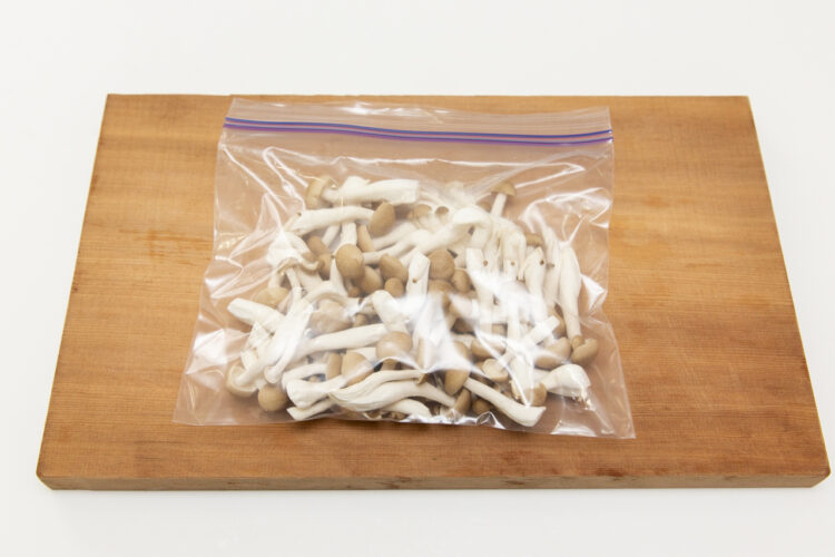 しめじをジッパー付き保存袋に空気を抜いて入れる