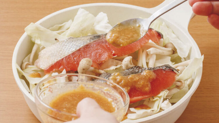 サケとキャベツのみそチーズ焼き②フライパンに1を敷いてサケをのせ、サケに塩、こしょうをふる。