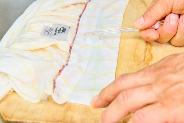 歯ブラシで洗濯洗剤をなじませる