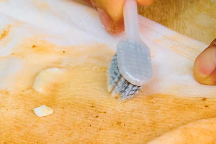 洗濯洗剤を歯ブラシで塗り広げる