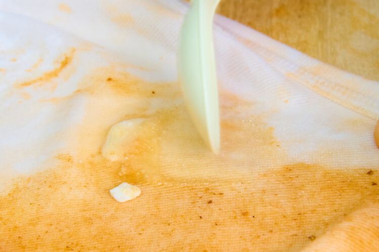 スプーンで油汚れをこすり洗いする