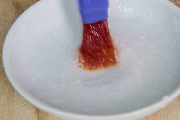 刷毛で漂白剤を混ぜ合わせる