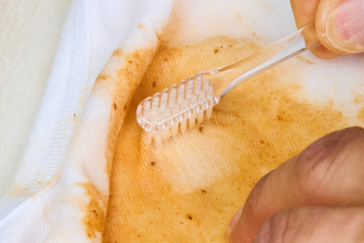 油汚れに歯ブラシで洗剤をすり込む