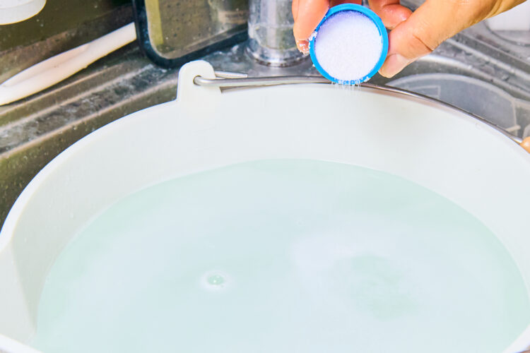 酸素系漂白剤をお湯に加えて混ぜ合わせる