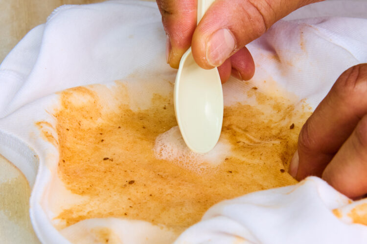 スプーンで油汚れをこすり洗いする