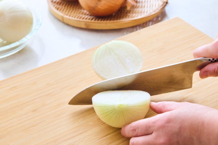 玉ねぎの皮をむいて縦半分に切る