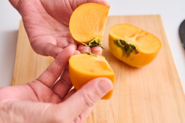 手で柿を4等分に割る