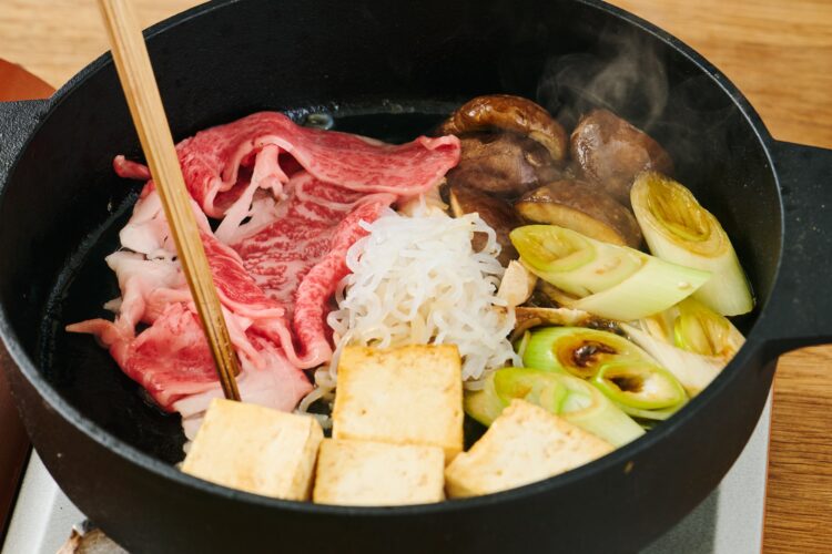 すき焼き鍋で牛肉と具材を同時に煮る様子