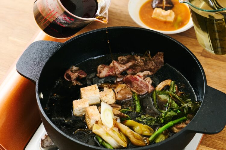 すき焼き鍋に割り下とだしを追加している様子