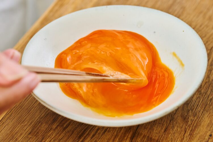溶き卵を箸で混ぜる様子