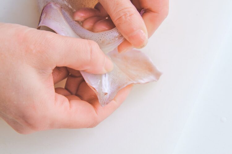 エンペラと胴のつなぎ目に指を入れ、皮を少しめくる