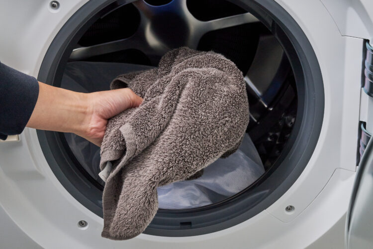 バスタオルを洗濯機に入れる図