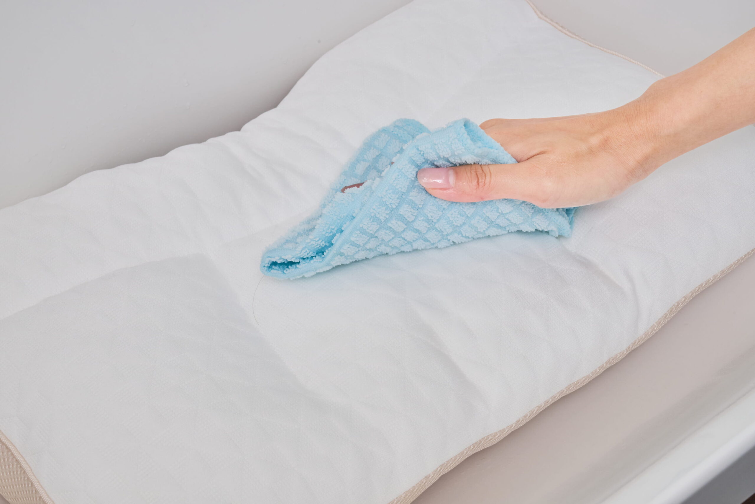 枕をタオルで拭く写真