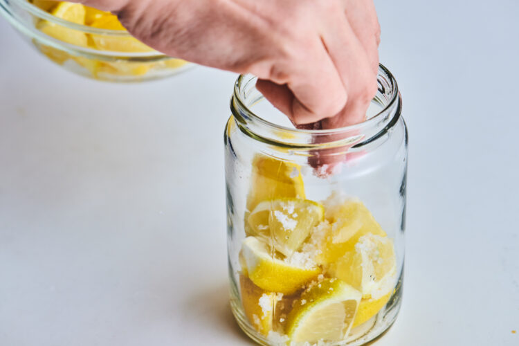 瓶に詰めたレモンの上から塩をかける