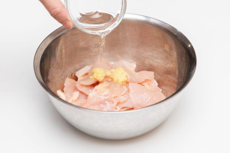 鶏肉に調味料を揉みこむ