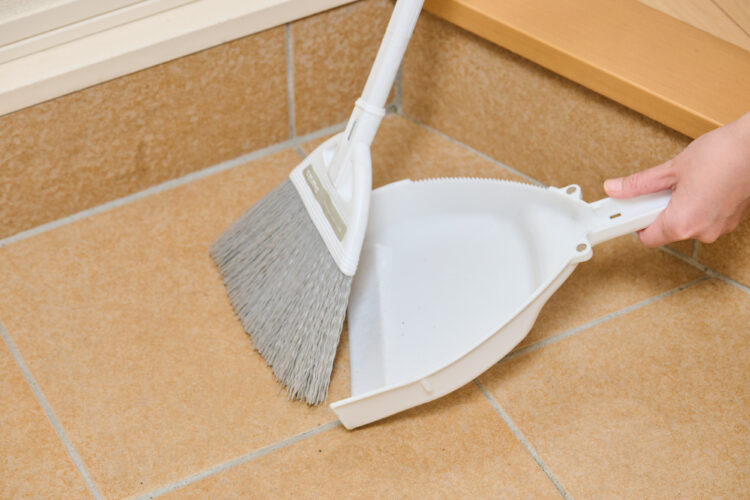 玄関タイル汚れをほうきで取り除く