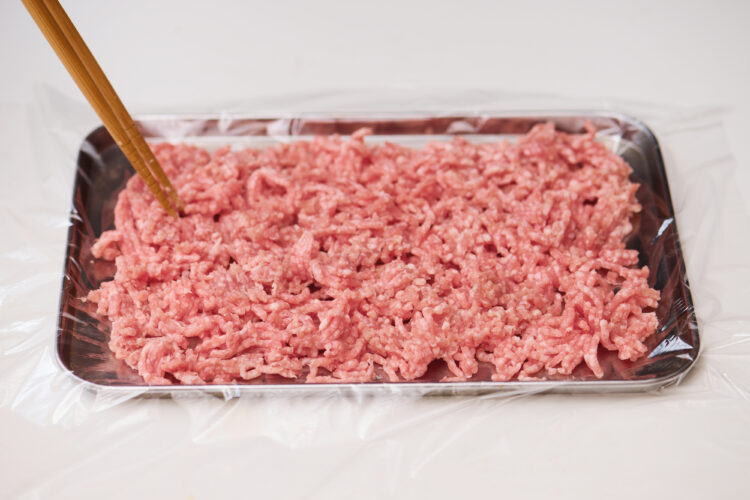 ひき肉を箸でほぐして広げる