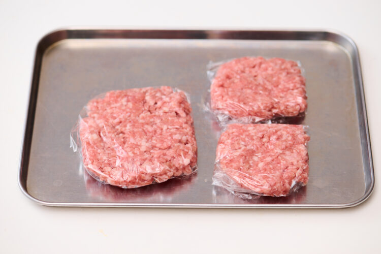 金属トレーにラップで包んだひき肉を並べる
