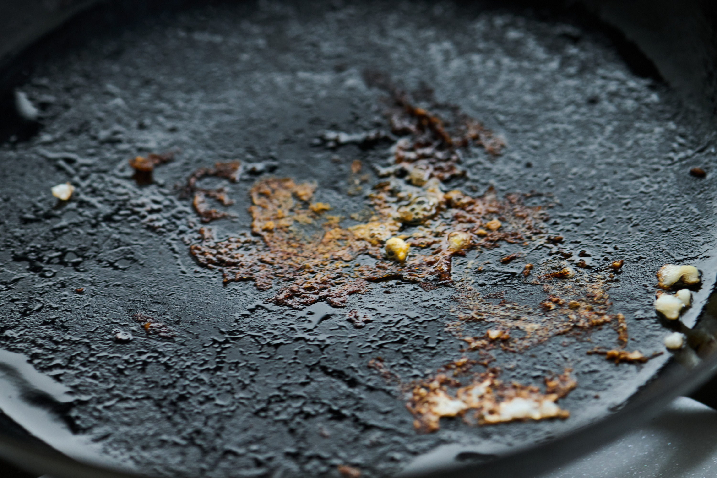 鉄フライパンを火にかけて熱し、焦げついた部分を完全に焼き切る