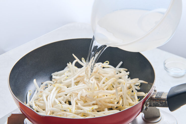 フライパンにもやしと水を入れる