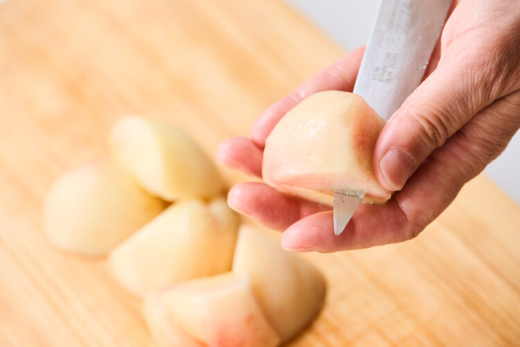 桃を少しずつ回しながら、種のまわりの果肉をすべて削ぎ落とす