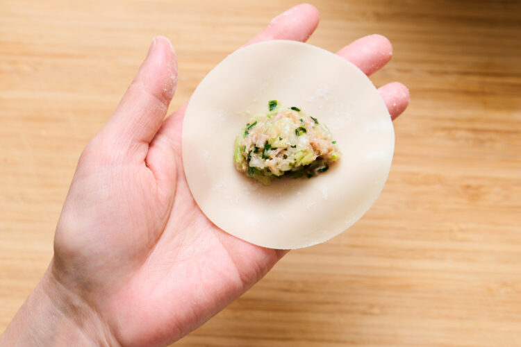1.餃子の皮の真ん中に、ティースプーン1杯分の具材をのせる（基本の包み方より具材はやや少なめに）